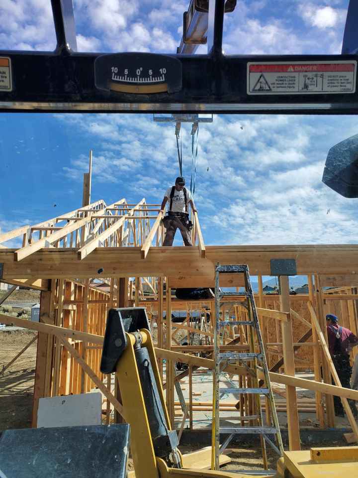 Frame of Custom built home with construction worker standing on top.