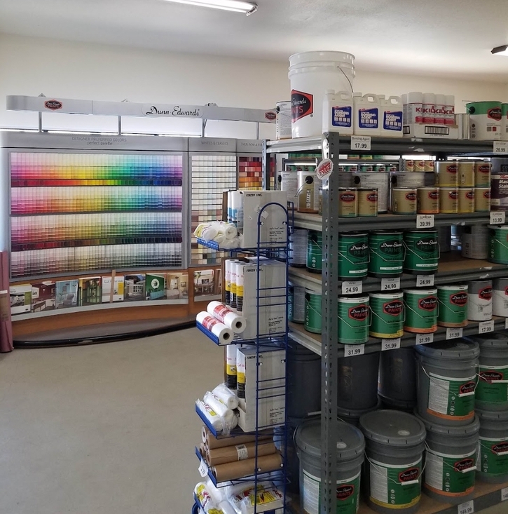 Interior of 1st Choice Paint Store showing swatches of colors in the background, with displayes of paint and supplies in the front.